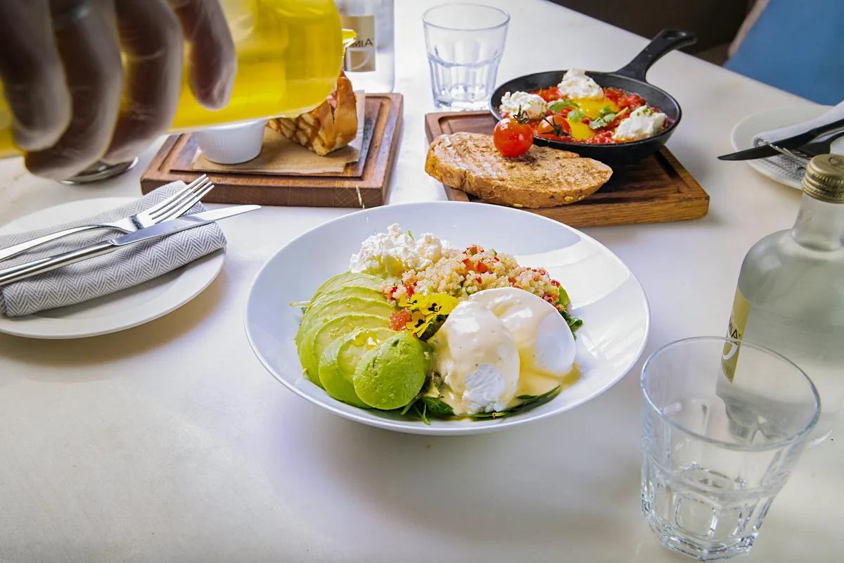 A delicious brunch with avocados and poached eggs, served in a Dubai café.